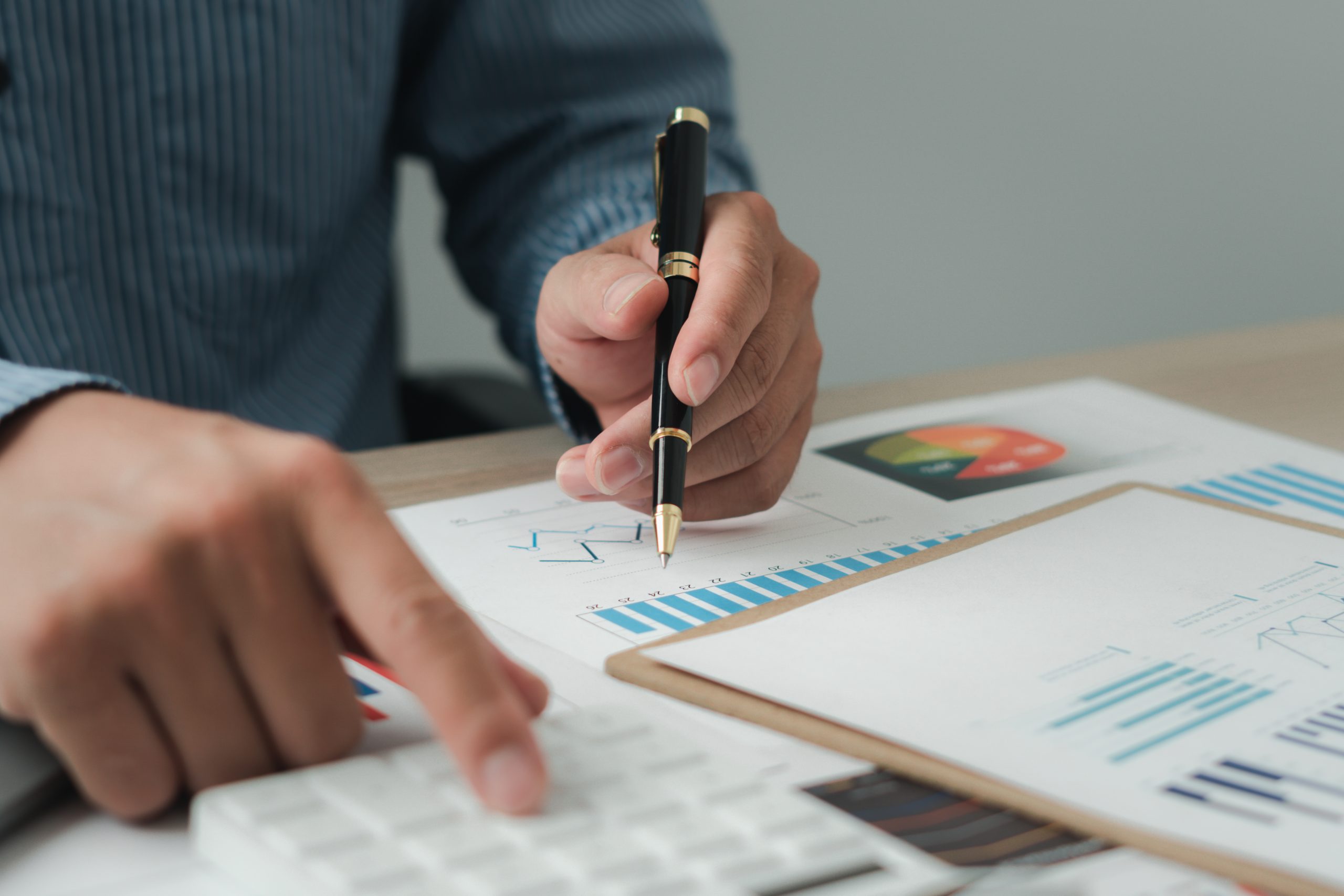 Businessman working on calculator to calculate business data the financial report. Business financial analysis and strategy concept.