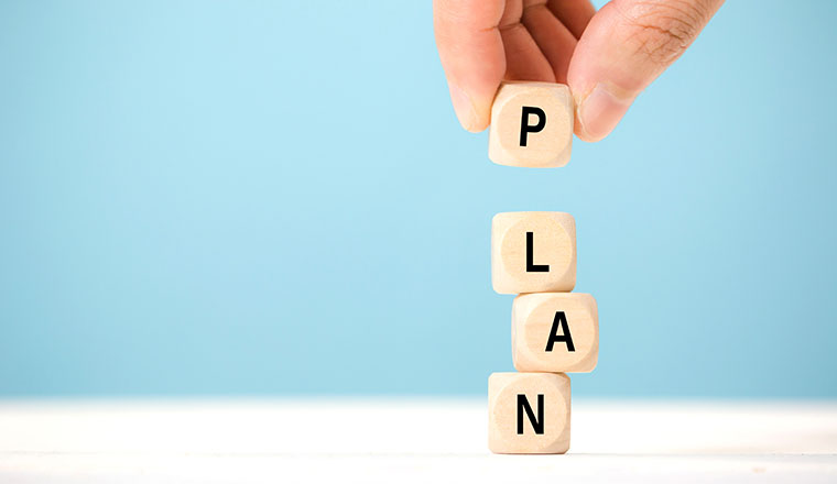 Hand hold wooden cube with PLAN word. The concept of planning in