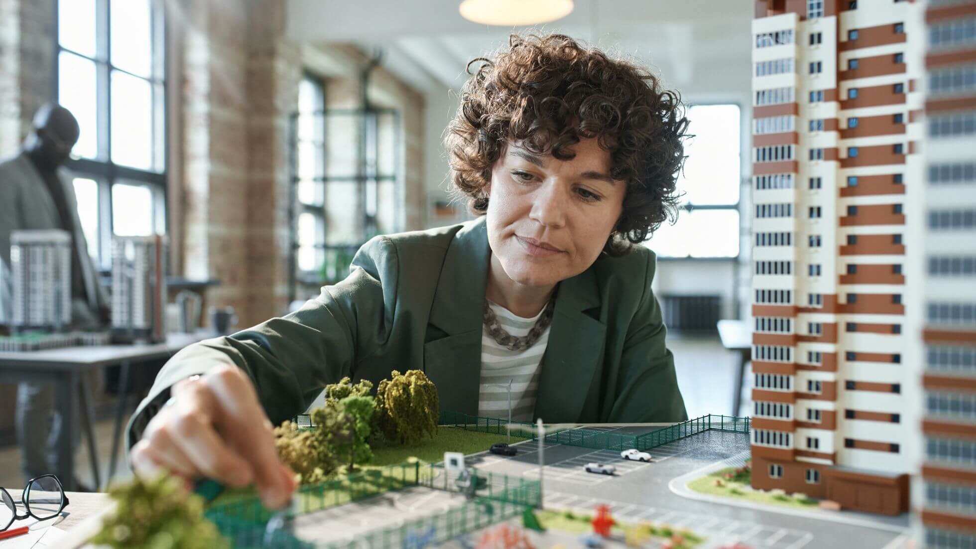 AI_for_building_permits_4 architect studying 3d model prototype of mid-rise building design and landscape