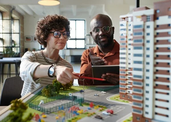 Two architects discussing construction mock-up of building development