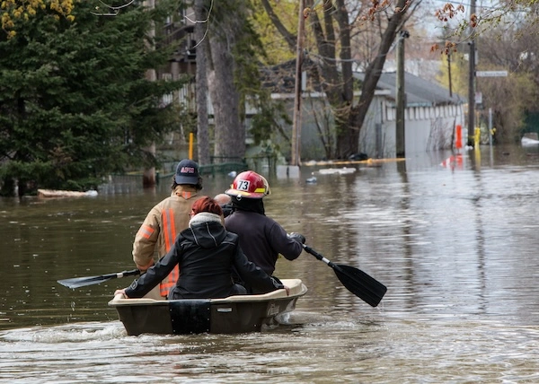 First responders row a couple away from danger after a surging river flooded houses in Montreal, Canada.