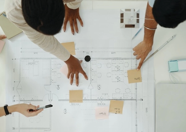 A small group of people reviewing a set of building plans.